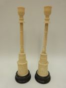A pair of Indian / Oriental candlesticks of column form,