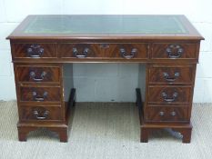 A leather inset twin pedestal desk fitted eight various drawers,