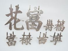 Two large Chinese white metal place settings in the form of Chinese characters, marked China,