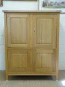A light oak four door cupboard with fitted interior,