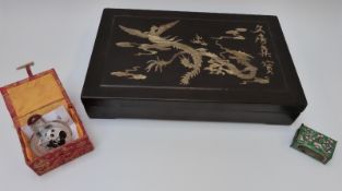 A Japanese hardwood box with inlaid mother of pearl decoration depicting a dragon chasing a flaming