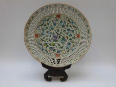 A 19thC Chinese pierced shallow bowl with flower and bird decoration on carved hardwood stand,