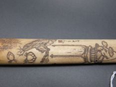 A Japanese bone pipe case with carved scene of a basket of fruit on a table and signature to one