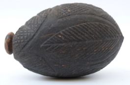 A 19thC carved and hollowed wooden vessel / carved nut with geometric design, 13 x 8.