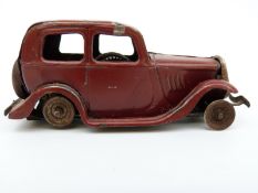 Tri-ang Minic clockwork tinplate Ford Saloon with maroon body and Shell petrol can
