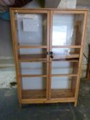 A pine display cabinet with adjustable shelves and glazed doors W115 x D39 x H178cm