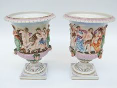 A pair of 19thC Continental campana urns decorated with relief moulded classical scenes