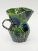 A studio pottery jug with mottled flambé type glaze, faint impressed B to base,