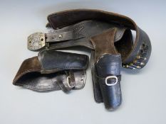 Two brown leather pistol / revolver holsters and a matching belt with dummy ammunition
