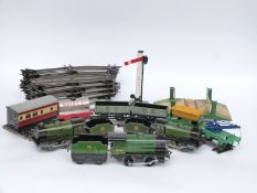 A quantity of Hornby 0 gauge items comprising three clockwork locomotive, five wagons and coaches,