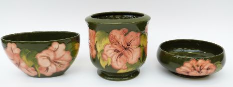 Three pieces of Moorcroft in Hibiscus pattern on a green ground