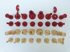 A late 18th/ early 19thC English Calvert carved ivory chess set with natural and stained red pieces,