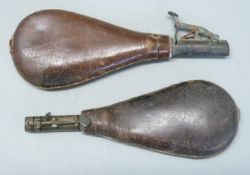 Two leather and brass shot flasks one with embossed decoration of game and guns, largest 22cm long.