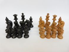 A late 19th/ early 20thC wooden Staunton pattern chess set with natural and stained black pieces,