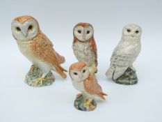 Four Beswick owls comprising three various sized barn owls and a snowy owl