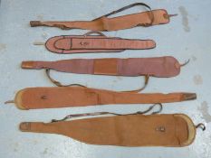 Five various canvas and leather gun slips.