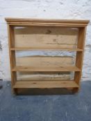 A wall mounted pine bookcase,
