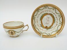 An 18thC Bristol Porcelain armorial teacup and saucer with blue cross mark to base,