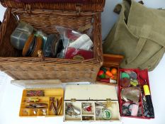 A collection of fishing equipment including a wicker basket,