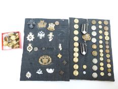 A collection of military cap badges and buttons including Navy, Royal Air Force and Army,