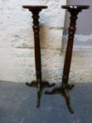 A pair of torcheres with carved tripod bases,