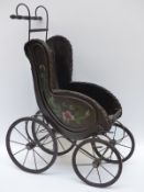 A Victorian style doll's pushchair with metal frame and wooden seat, 79cm tall.