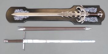 Two modern replica swords, one Braveheart in scabbard, the other a fantasy sword on display plaque,