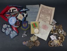 A collection of military badges, cloth insignia,
