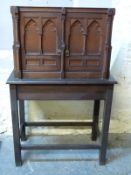 A 19thC Gothic style cupboard on stand with carved decoration,
