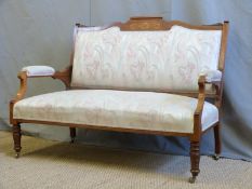 An Edwardian two-seat settee, the rosewood frame with string inlay and carved detail,