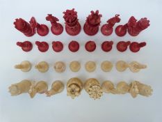 A 19thC Indian Kashmir finely carved ivory chess set with natural and stained red pieces,