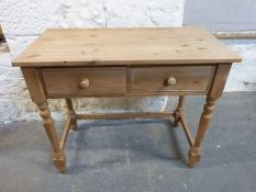 A pine desk fitted two drawers raised on turned legs,
