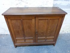 An oak cupboard with panelled doors W96 x D33 x H81cm