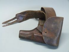 A brown leather pistol holster with magazine pouch, 28cm long, mounted on a belt.