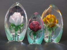Three Mats Jonasson coloured floral paperweights,
