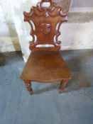 A 19thC mahogany hall chair with carved back