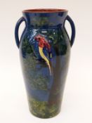 A twin-handled Torquay pottery vase with hand-decorated parrot in relief,