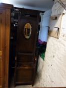 An Edwardian oak hall stand with inset bevelled oval mirror and built in lidded bench seat,
