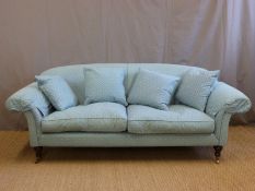A Howard style sofa raised on turned legs,