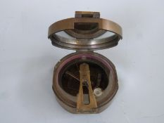 A brass military compass marked Brinton Compass,