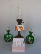 An oil lamp and two enamelled glass decanter jugs