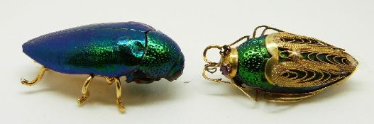 A yellow metal filigree brooch set with a beetle and another beetle brooch