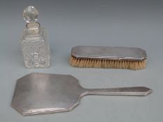 An Art Deco style hallmarked silver mounted hand mirror and matching brush,