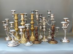 A collection of plated, brass and other candelabra,