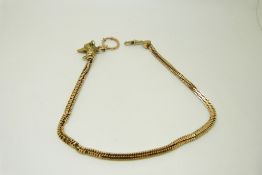 A yellow metal fob chain made up of rectangular links with a textured dog head set with garnet eyes,