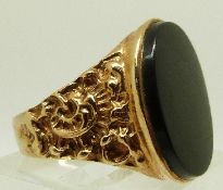 A 9ct gold ring set with onyx and textured shoulders, size U, 6.
