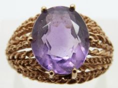 A 9ct gold ring with rope twist shoulders set with an oval amethyst, size M, 4.