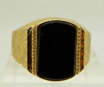 A yellow metal ring set with onyx and textured shoulders, 5.
