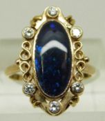 An 18ct gold Victorian ring set with an oval black opal cabochon and diamonds around the pierced