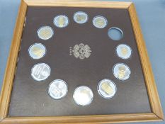 A framed collection of silver / gilt cameo style Museo Nacional De Antropologia coins with Aztec